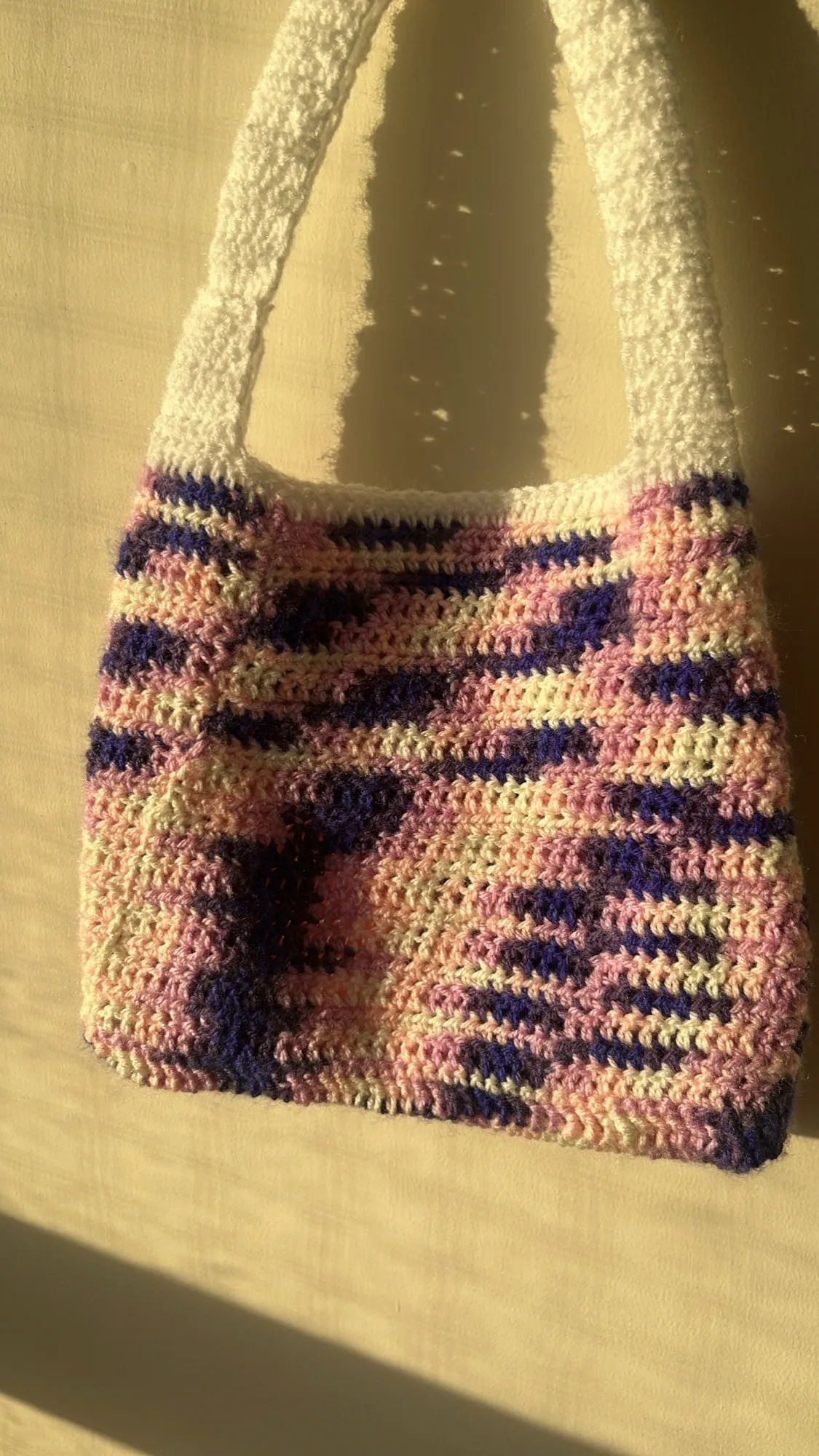 A pink and lilac crochet shoulder bag with blended colour shifts