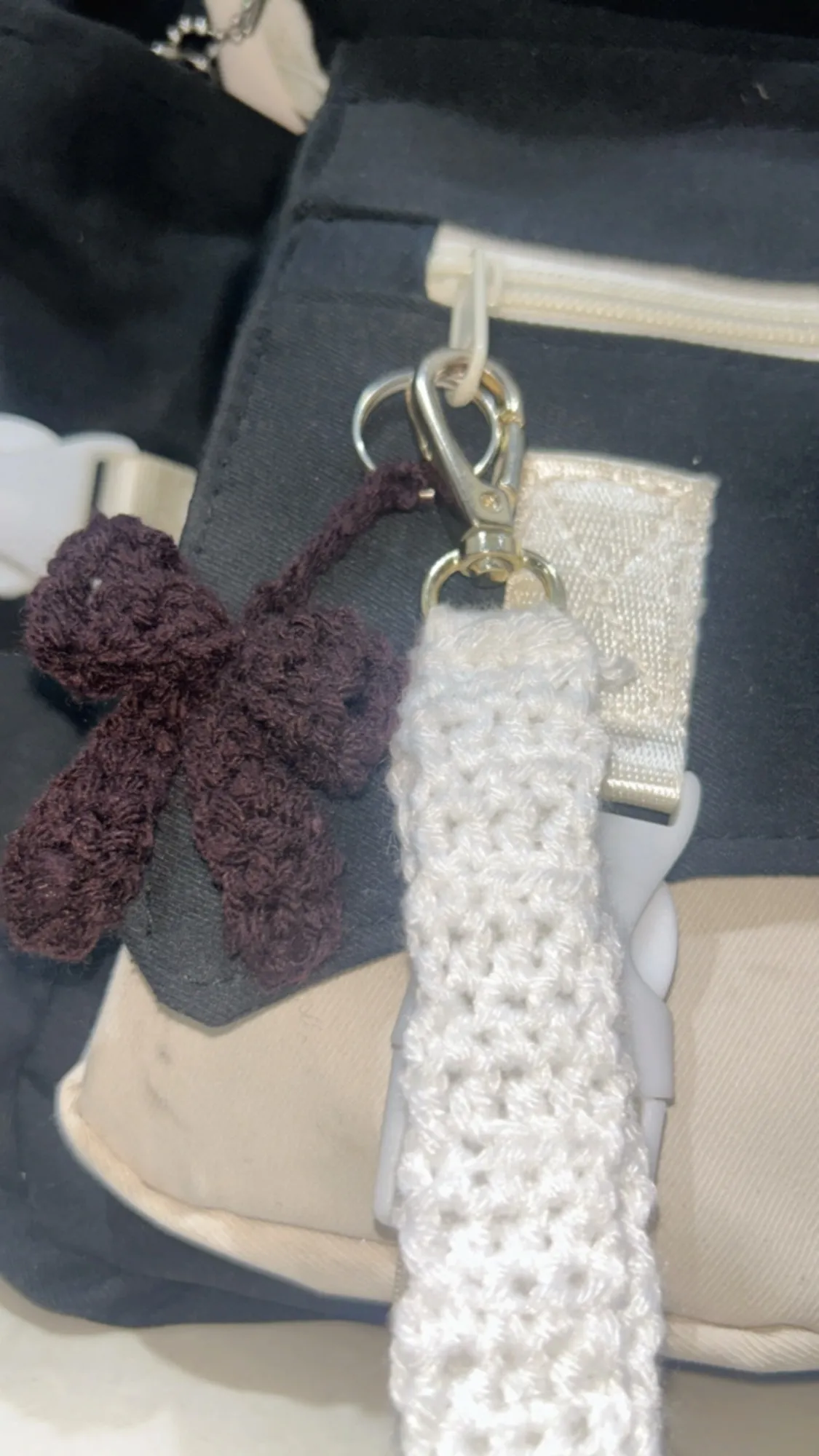 A burgundy crochet bow charm on a handbag